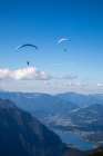 Austria-Dachstein-Paragliders as they soar above Lake Hallstatt and the surrounding mountains Art Print